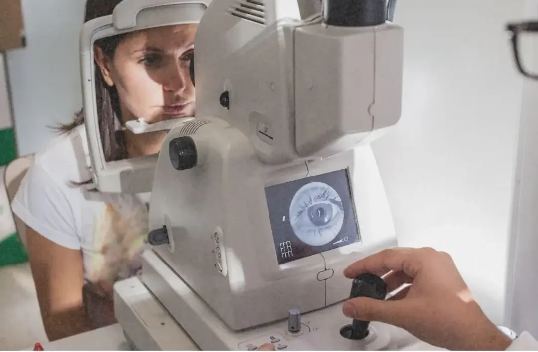 Pessoa realizando exame de vista em equipamento clínico
